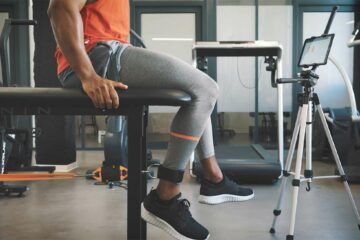 Sportif assis utilisant un capteur de force relié à sa jambe
