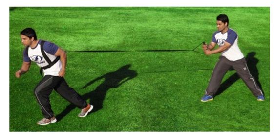 jeune sportif utilisant un harnaiis relié à un élastique