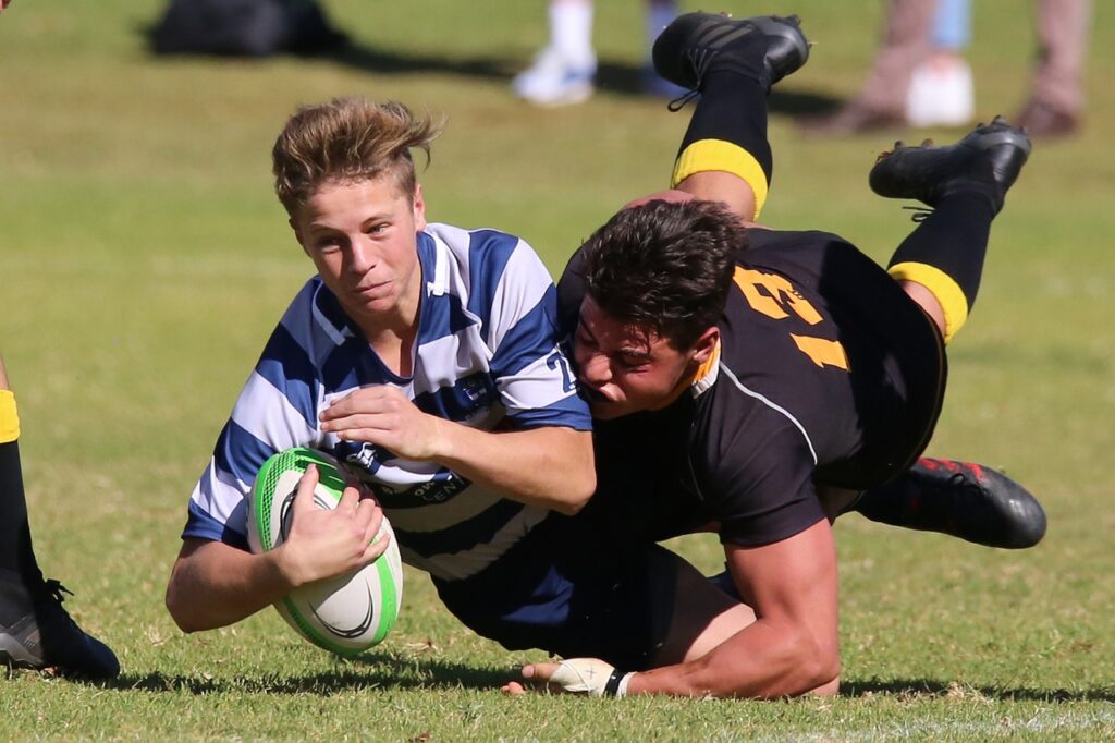 Deux jeunes garçon faisant un plaquage au rugby, une des causes de déchirure intercostale