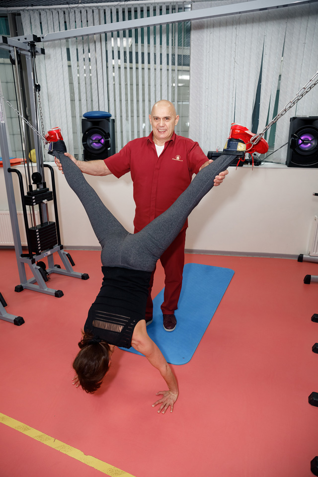 Un kiné russe avec une patiente faisant une décompression des hanches avec poulies