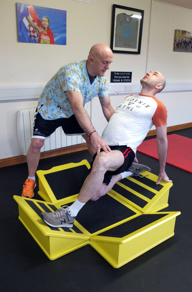 Anthony Geoghegan montrant un étirement du psoas sur le Speedboard.